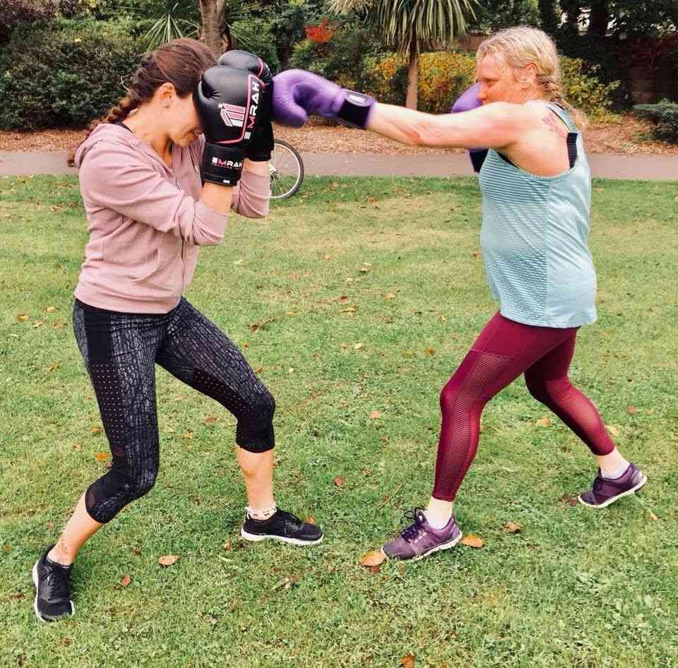Two women sparring in the park